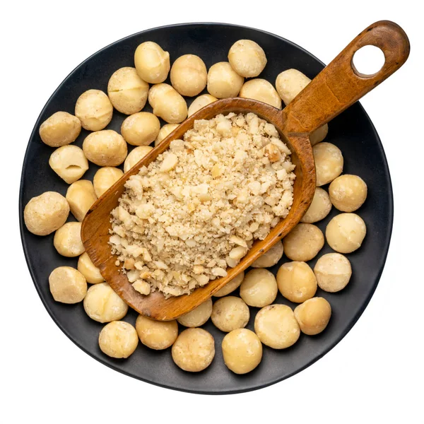 Macadamia Notenmeel Houten Bolletje Een Zwarte Keramische Plaat Geïsoleerd Witte — Stockfoto