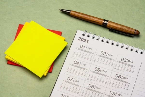 2021年スパイラルデスクトップカレンダーコピースペース 時間管理とビジネスコンセプトとテクスチャ紙に対してペンと粘着ノートパッド — ストック写真