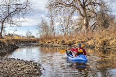 Son sınıf öğrencisi erkek, bahar başlarında Colorado 'nun kuzeyinde Poudre Nehri' nde şişme bir yük teknesinde kürek çekiyor.