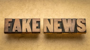 Sahte haber kelimesi eski harflerle soyut grunge kağıt, sosyal medya ve enfodemik konsepte karşı ahşap baskı tipi