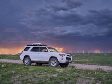 Keota CO, ABD - 7 Haziran 2021: Toyota 4Runner SUV (2016 Trail versiyonu) Kuzey Colorado Pawnee Ulusal Çayırı 'nda, fırtınalı bir gün batımı gökyüzü ile bahar sonu manzarası.
