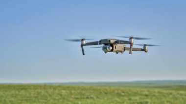 Yeni Raymer, CO, ABD - 8 Haziran 2021: Radyo kontrollü DJI Mavic 2 Pro kuadcopter İHA yeşil çayır üzerinde uçuyor.