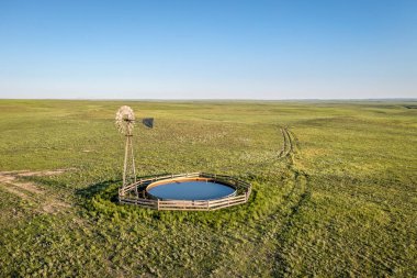 windmill with a water pump and tank  in shortgrass prairie, Pawnee National Grassland in Colorado, aerial view clipart