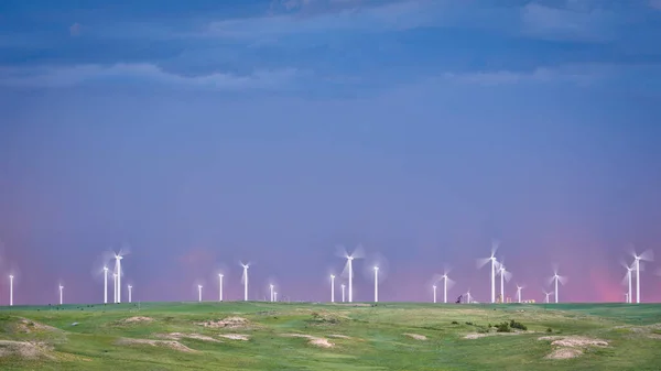 コロラド州ポーニー国立草原の風力発電所 石油採掘リグと牛 嵐の夕日の空に対する晩春または初夏の風景 — ストック写真