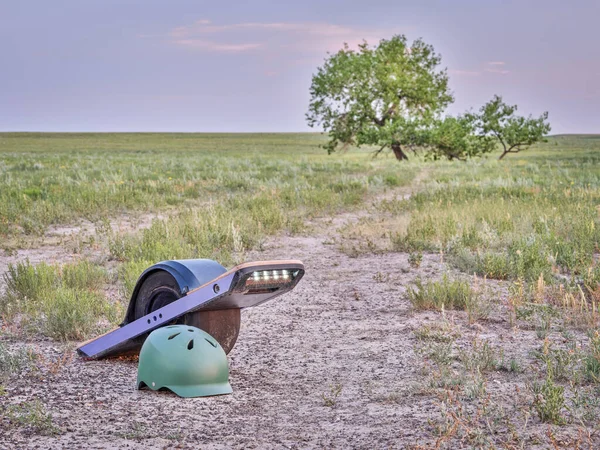 草原の未舗装の歩道上の電動スケートボード 個人用輸送機 とヘルメット — ストック写真