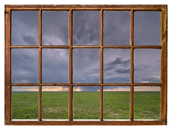 春の終わりか初夏の緑の草原の嵐の雲ヴィンテージのサッシ窓から見た景色 — ストック写真