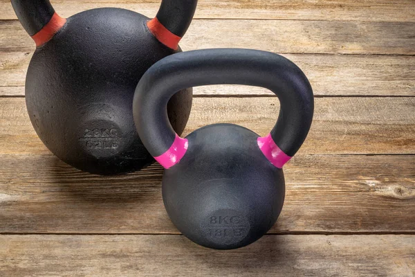 Two Heavy Iron Kettlebells Rustic Wood Background Weight Training Fitness — Stock Photo, Image