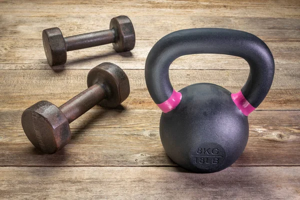 Kleine Eisenkettlebell Und Ein Paar Kurzhanteln Auf Rustikalem Holzhintergrund Bewegungs — Stockfoto