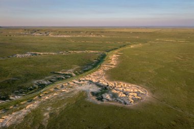 Kuzey Colorado 'daki Pawnee Ulusal Çayırlığı' ndaki arroyo ve çorak topraklar üzerinde gözcü ışığı, yaz başlarındaki hava manzarası