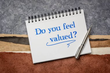 Değerli hissediyor musun? Soyut kağıt manzarasına karşı bir deftere el yazısı. İş, iş ve kişisel gelişim kavramı.