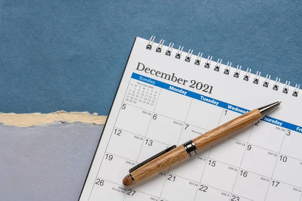 2021年12月 スタイリッシュなペン ビジネスコンセプトの抽象的な紙の風景に対するスパイラルデスクトップカレンダー — ストック写真