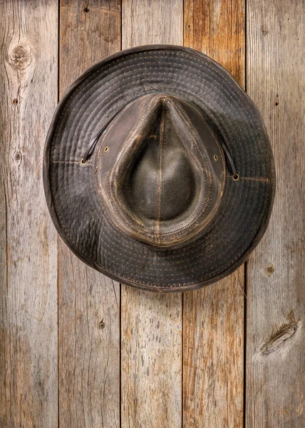 Kırsal Ahır Ahır Ahşap Duvarında Asılı Eskimiş Yağ Tulumu Şapka — Stok fotoğraf