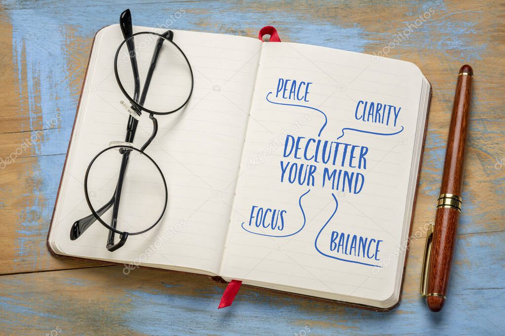 Declutter your mind for clarity, peace, focus and balance - handwriting in a notebook or journal with acup of tea, minimalism, self care and personal development concept.