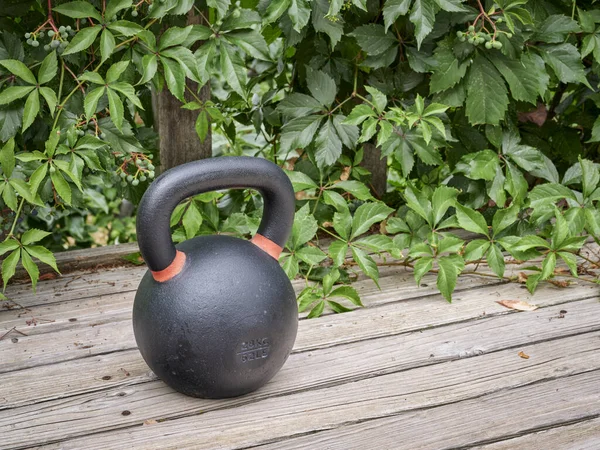 重铁球比赛水壶 用于木制格子甲板上的重量训练 家庭体操和健身概念 — 图库照片