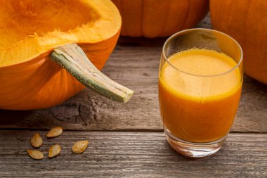 bir bardak taze kabak suyu kesilmiş kabak ve tohum rustik ahşap tablo