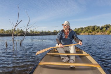 bir gölde kano kürek çekmeye