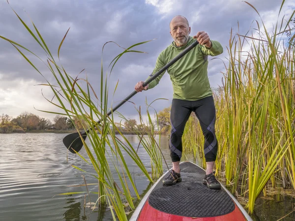 De pie remando en un lago —  Fotos de Stock