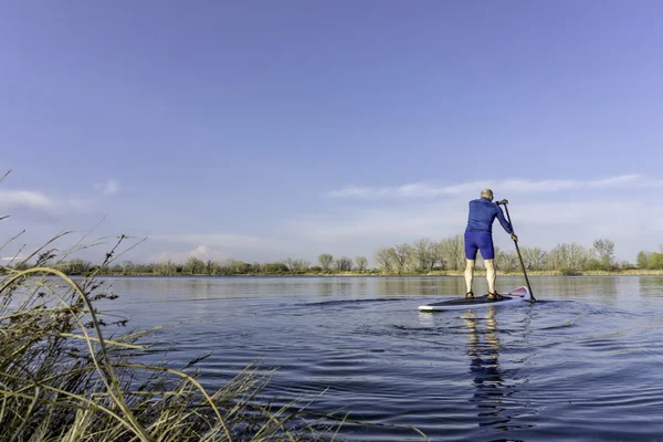 Senior male on SUP paddleboard — Stock Photo, Image