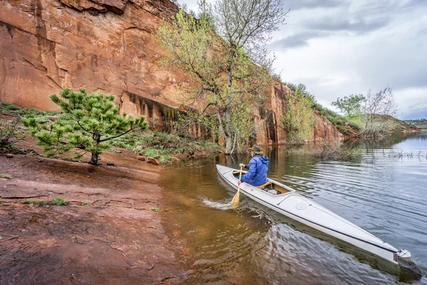 Canoe paddler and sandstone cliff — Stock Photo, Image