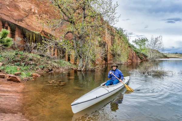 Senio canoa paddler vicino scogliera di arenaria — Foto Stock