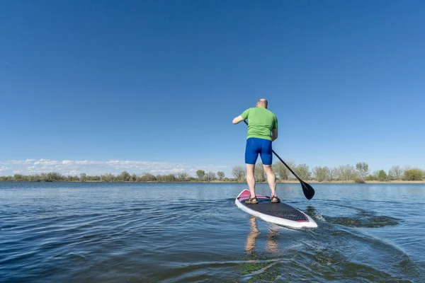 De pie remando en un lago —  Fotos de Stock