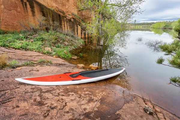 Stand up paddleborad na margem do lago — Fotografia de Stock