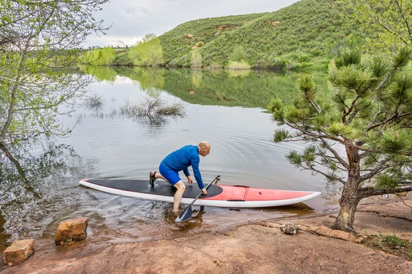 Senior paddlaren lansera paddleboard — Stockfoto