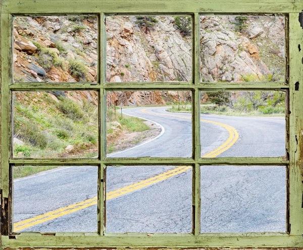 Concetto di viaggio - strada ventosa attraverso la vecchia finestra — Foto Stock