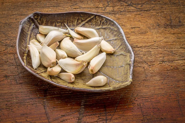 Knoflookteentjes op een blad bowl — Stockfoto