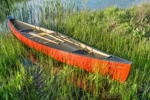 Red canoe with wooden paddles — Stock Photo, Image