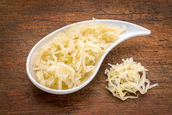 Bowl of sauerkraut against rustic wood — Stock Photo, Image