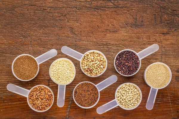 Gluten free grains - measuring scoops on wood — Stok fotoğraf