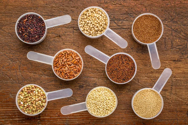 Gluten free grains - measuring scoops on wood — Stok fotoğraf