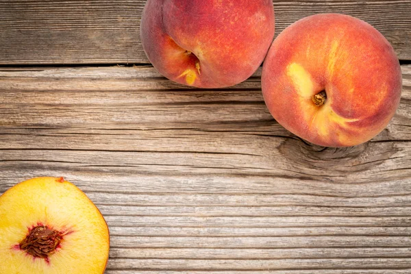 Peach fruits on weathered wood — Stock Photo, Image