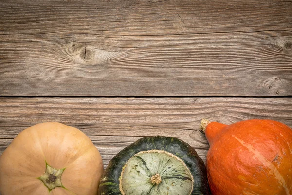 Rustieke houten achtergrond met winter squash — Stockfoto