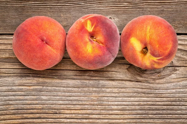 Peach fruits on weathered wood — Stock Photo, Image