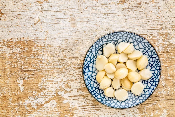 Nueces de macadamia en tazón de cerámica —  Fotos de Stock