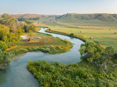 Nebraska Kum Tepeleri 'nden geçen Ortanca Loup Nehri üzerinde gün doğumu. Nebraska Kum Tepeleri' nde nehir gezileri için kanolar ve su tankları vardı.
