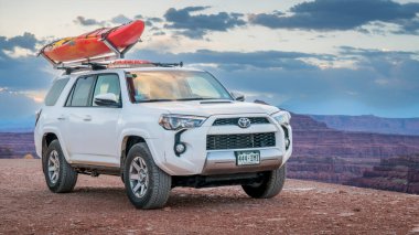 Potash, UT, ABD - 7 Mayıs 2017: Toyota 4runner SUV Colorado nehir kanyonunda beyaz su kanosuyla Moab yakınlarında..