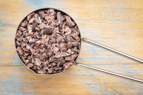 Plumas de cacao en bruto en cuchara de metal — Foto de Stock