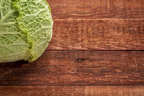 Savoy cabbage on rustic wood — Stock Photo, Image