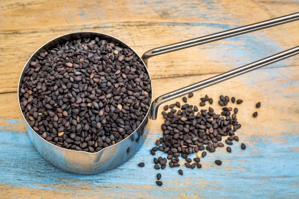 Cucharada de semillas de sésamo negro — Foto de Stock