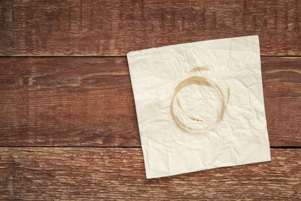 Napkin with coffee stains on wood — Stock Photo, Image