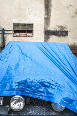 Mavi plastik kapak ile korunan araç 
