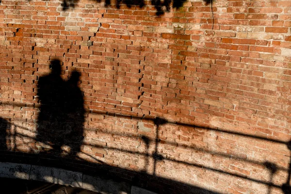 Gente caminando, proyectando sombras en una pared —  Fotos de Stock