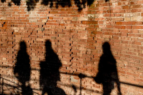 Gente caminando, proyectando sombras en una pared —  Fotos de Stock