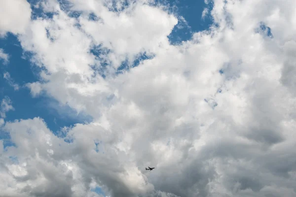 Airplane flying high in dramatic clouds — Stock Photo, Image