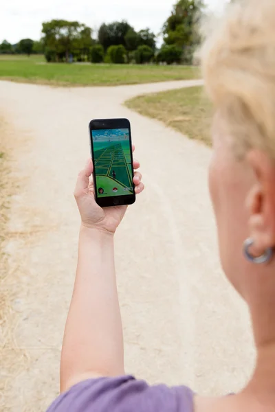 Playing Pokemon Go in the park — Stock Photo, Image