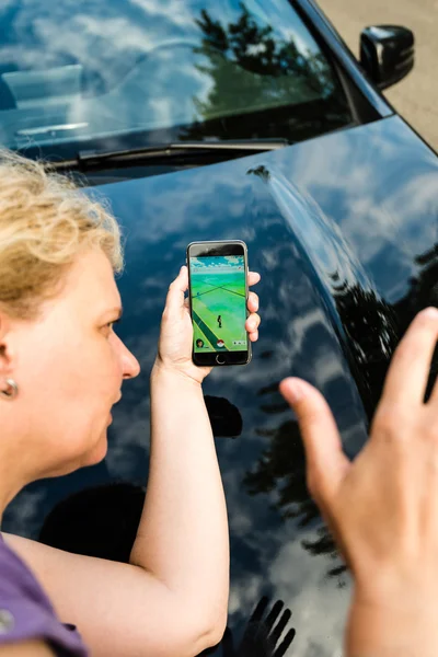 Fußgängerin wird beim Pokemonspiel auf ihrem Smartphone von Auto angefahren — Stockfoto