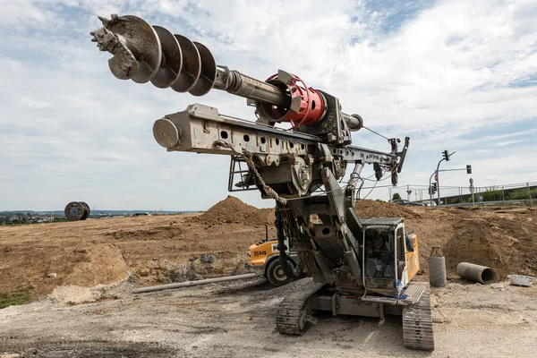 Large rotary drill and excavator on construction site — Stock Photo, Image